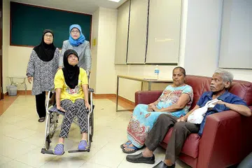 KEMBALIKAN SINAR HARAPAN: Pesakit strok yang belum pulih sepenuhnya seperti Cik Hayati Samsudin (berkerusi roda) dan Cik Shobana Raghavan (dua dari kanan), serta penjaga mereka, Cik Nyamah Abdul Manaf (berdiri, kiri) dan suami Cik Shobana, Encik Krishna Madhadan, akan dapat memanfaatkan program Stesen Sokongan Strok (S3) yang bakal diperkenal kepada penduduk GRC Marsiling-Yew Tee menyusuli persetujuan Speaker Parlimen, Cik Halimah Yacob (berdiri, dua dari kiri), dengan pengasas serta pengerusi program itu, Cik Chew Poh Yim. - Foto M.O. SALLEH