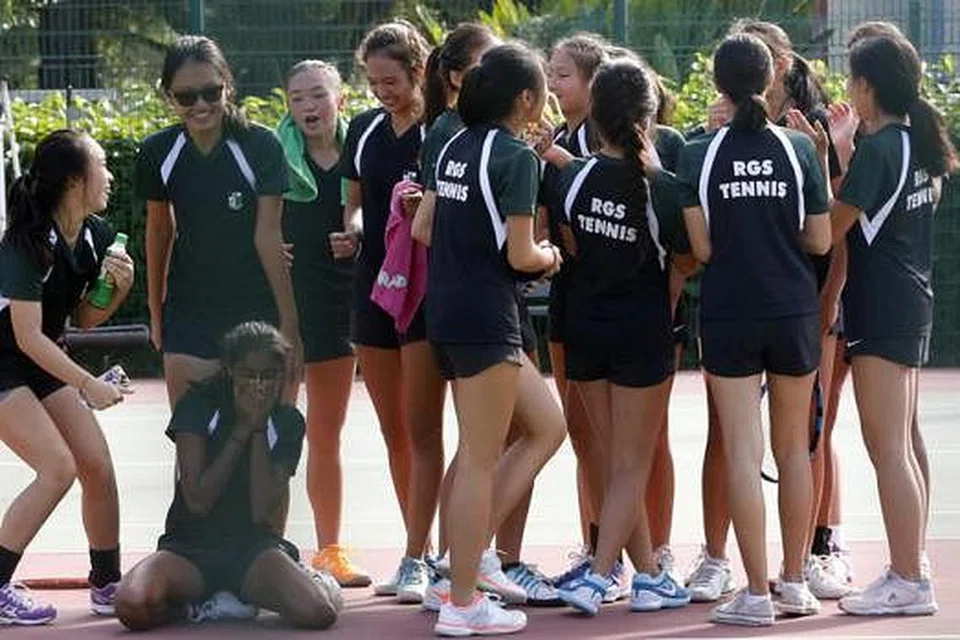 SORAKAN KEGEMBIRAAN: Pasukan tenis Sekolah Perempuan Raffles bersorak kegembiraan setelah berjaya menewaskan juara bertahan, Sekolah Perempuan Methodist, di Pusat Tenis Kallang. - Foto THE STRAITS TIMES