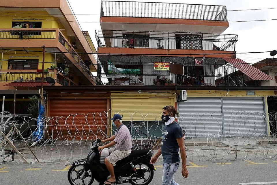 SEMUA DITUTUP: Penduduk setempat memakai pelitup di Selayang, Selangor, sedang Kawalan Pergerakan Diperketatkan (KPKD) dikuasa kuasa dimulai 25 April hingga 3 Mei bagi terus mengekang penularan jangkitan Covid-19 di situ. - Foto REUTERS