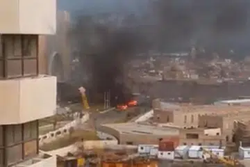 KESAN LETUPAN: Gambar yang diambil menunjukkan asap dan kebakaran di depan Hotel Corinthia di Tripoli selepas tiga lelaki bersenjata menyerbu masuk hotel mewah itu. - Foto AFP
