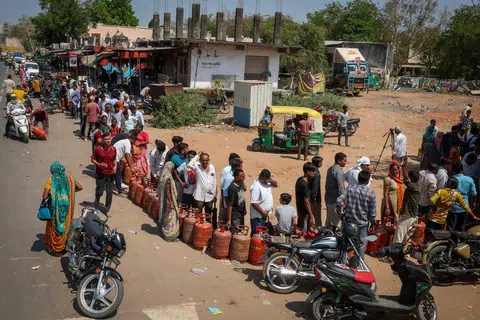Orang ramai beratur sambil memegang silinder gas LPG kosong di luar sebuah agensi gas susulan gangguan bekalan akibat konflik antara Amerika Syarikat dan Israel dengan Iran di Ahmedabad, India, pada 12 Mac 2026. 