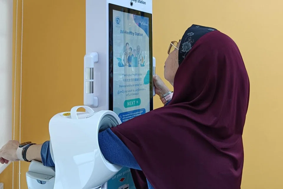 Cik Rubiah Rahim menggunakan ‘IM-Healthy’ untuk menilai suhu, tekanan darah dan kadar denyutan jantung di Pusat Penuaan Aktif (AAC) Lions Befrienders @ 420A Clementi.