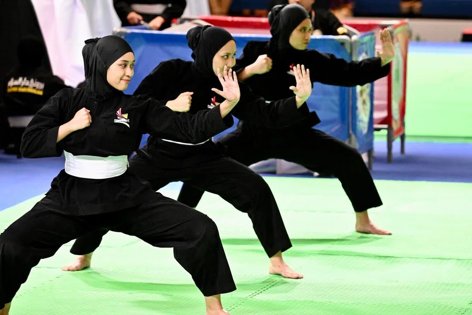Pasukan silat seni (dari kiri) Iffah Batrisyia Noh, Nur Ashikin Zulkifli dan Amirah Sahrin memenangi pingat emas silat yang pertama untuk Singapura semasa temasya Sukan SEA 2023 di Kemobja.