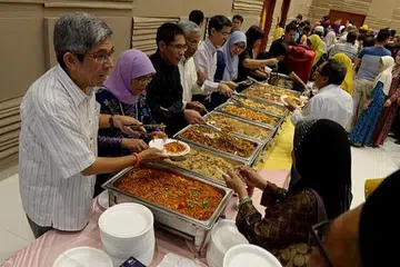 BERI JAMUAN: (Dari kiri) Dr Yaacob Ibrahim, Cik Halimah Yacob, Dr Maliki Osman, Encik Hawazi Daipi, Dr Muhammad Faishal Ibrahim dan Dr Intan Azura Mokhtar menghidangkan jamuan kepada para pekerja di majlis iftar. - Foto TUKIMAN WARJI
