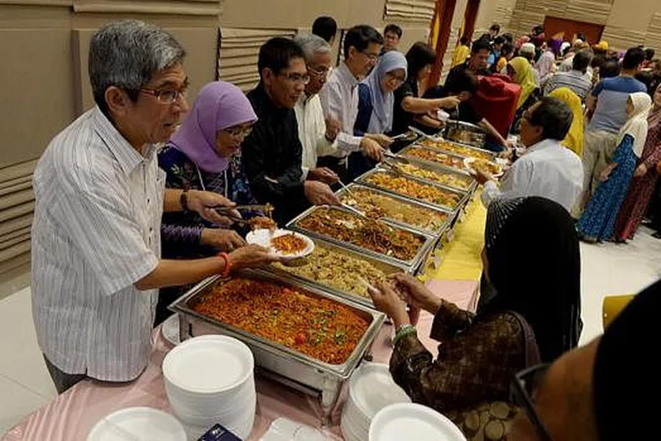 BERI JAMUAN: (Dari kiri) Dr Yaacob Ibrahim, Cik Halimah Yacob, Dr Maliki Osman, Encik Hawazi Daipi, Dr Muhammad Faishal Ibrahim dan Dr Intan Azura Mokhtar menghidangkan jamuan kepada para pekerja di majlis iftar. - Foto TUKIMAN WARJI