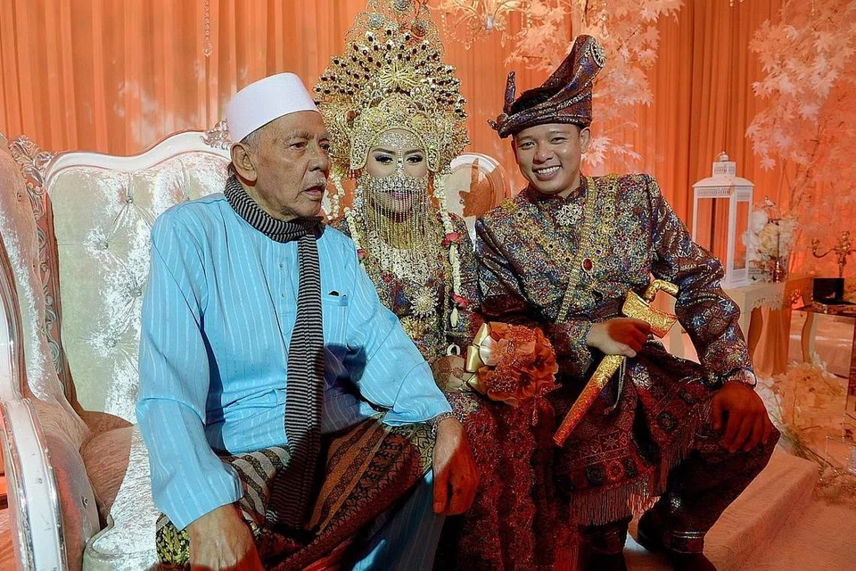 DATUK PENYAYANG: Hady Mirza (kanan), yang ditemani isteri dan datuknya, Allahyarham Osman Zailani (kiri), sewaktu majlis pernikahannya pada 2014, terharu dengan pesanan terakhir datuknya yang memintanya agar tidak melupakan solat dan amanahnya.