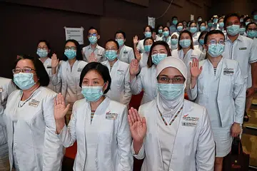 IKRAR JURURAWAT: Jururawat mengambil ikrar sewaktu majlis sambutan Hari Jururawat yang diadakan SingHealth semalam. Sambutan ini diadakan sebelum Hari Jururawat di Singapura pada 1 Ogos. - Foto BH oleh KUA CHEE SIONG