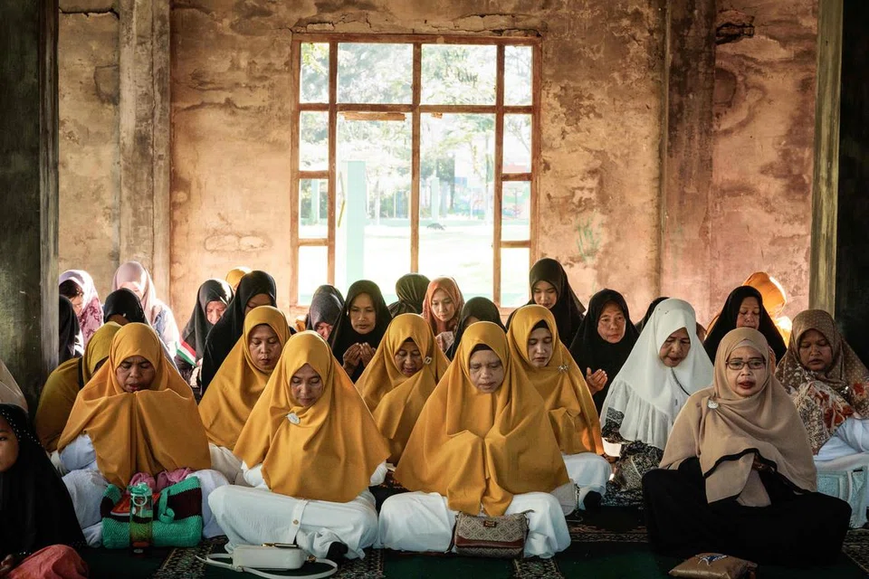 Umat Islam berdoa di tapak pusat kesihatan yang musnah bersebelahan dengan tanah perkuburan besar Ulee Lheue, salah satu daripada dua lokasi utama mangsa tsunami Lautan Hindi 2004 dikebumikan, di Banda Aceh, Indonesia.