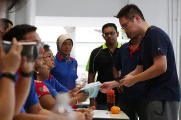 Seorang penduduk sedang mengambil pelitup muka di pusat RC di Blk 47, Telok Blangah Drive, yang diberikan percuma oleh pemerintah dalam usaha membantu warga di tengah-tengah penularan virus korona novel. 