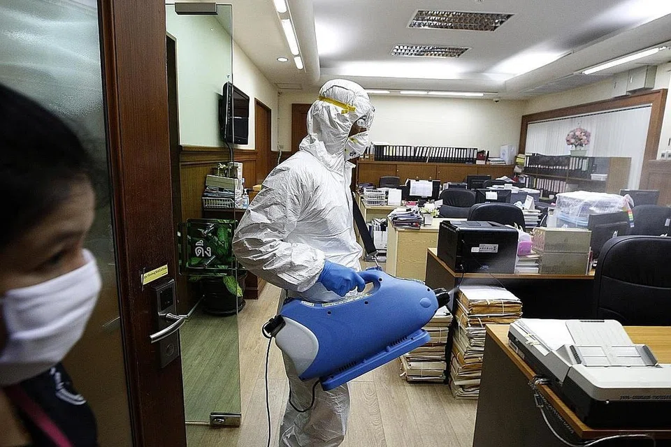 TINGKAT PEMBERSIHAN: Pekerja pembersihan di Thailand ini sedang membasmi kuman dari dalam pejabat sebagai langkah mengekang Covid-19 di bangunan Bangkok Metropolitan Administration semalam. - Foto EPA-EFE