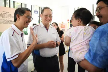 Profesor Madya Dr Muhammad Faishal Ibrahim (kiri) dan Dr Tan See Leng beramah-tamah bersama penduduk semasa sebuah karnival anjuran Rangkaian Penduduk (RN) Eunos pada 12 April.