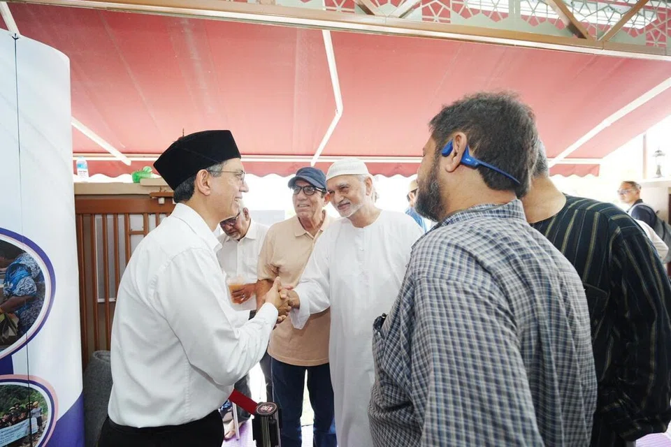 Pemangku Menteri Bertanggungjawab bagi Ehwal Masyarakat Islam, Profesor Madya Dr Muhammad Faishal Ibrahim (kiri), beramah mesra dengan jemaah selepas solat Jumaat di Masjid Al-Abdul Razak pada 16 Januari.