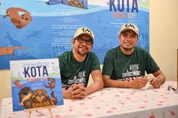 PENUHI KEKURANGAN: Pasangan adik-beradik Encik Rhaimie Wahap (kiri) dan Encik Rizal Wahap melancarkan buku dwibahasa ‘Memerang Di Kota’ kerana berasa terdapat kekurangan buku tentang alam sekitar dalam pasaran buku bergambar dan landskap pendidikan Singapura.