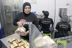 MAHU TERUS PRODUKTIF: Cik Sariman (kiri) antara contoh pekerja warga emas yang bertekad terus bekerja selagi mampu dan sihat. - Foto fail