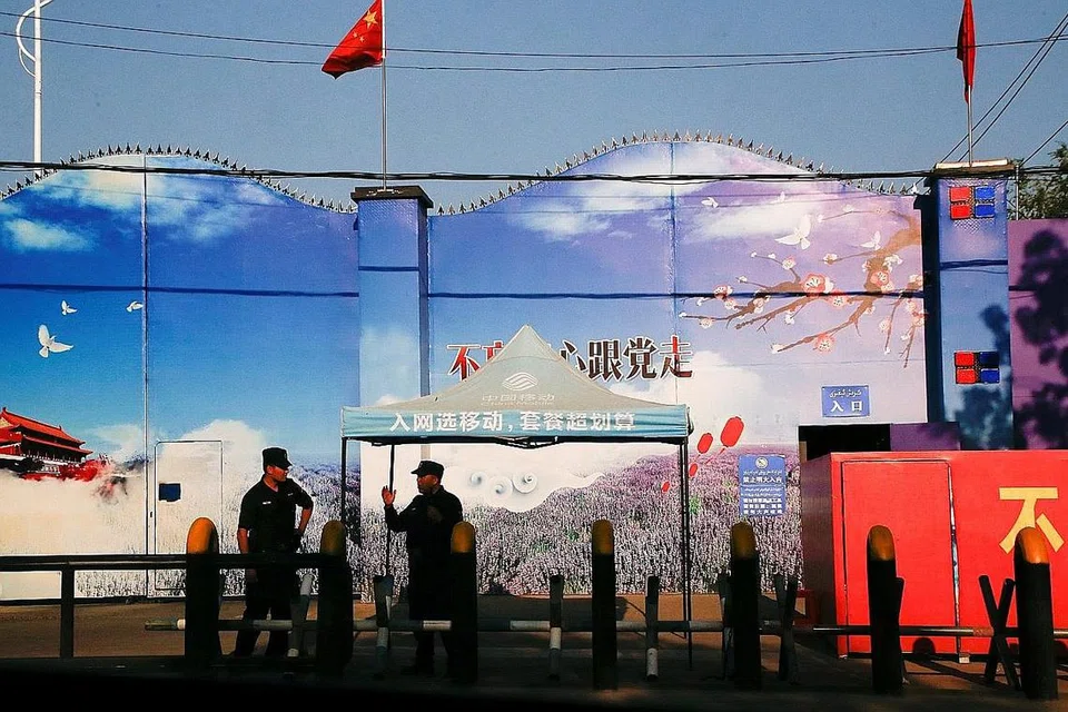 KAWAL KETAT: Pengawal keselamatan berjaga di pintu masuk pusat pendidikan kejuruan di Daerah Huocheng, Xinjiang di Rantau Autonomi Uighur, China. Pusat ini terletak berdekatan sempadan Kazakhstan. Kelihatan tembok tinggi dihiasi dengan sepanduk propaganda dan pintu masuk, diwarnai dengan bendera China. Beberapa negara Barat mendakwa warga Uighur dipaksa memasuki pusat ini untuk mempelajari budaya dan fahaman China dan mengenepikan identiti Muslim mereka. China membantah dakwaan tersebut - Foto REUTERS 