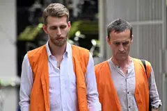 Warga Britain Kial Garth Robinson (kiri) dan Piran Ezra Wilkinson (kanan) berjalan menuju ke bilik mahkamah semasa perbicaraan mereka di Denpasar, pulau peranginan Bali, Indonesia pada 26 Februari 2026. Dua lelaki Britain itu dijatuhi hukuman penjara panjang oleh mahkamah Indonesia selepas didapati bersalah menyeludup kokain ke pulau pelancongan popular tersebut.