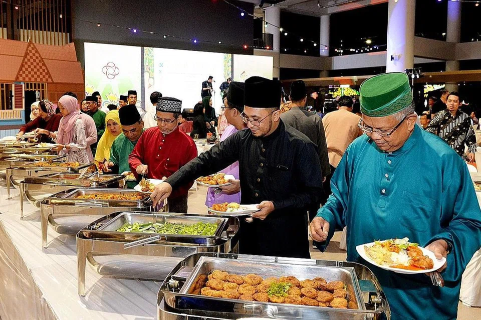  JAMUAN: Hadirin menikmati jamuan yang dihidangkan di perjumpaan Hari Raya BH dan Wisma Geylang Serai. - Foto BM oleh KHALID BABA