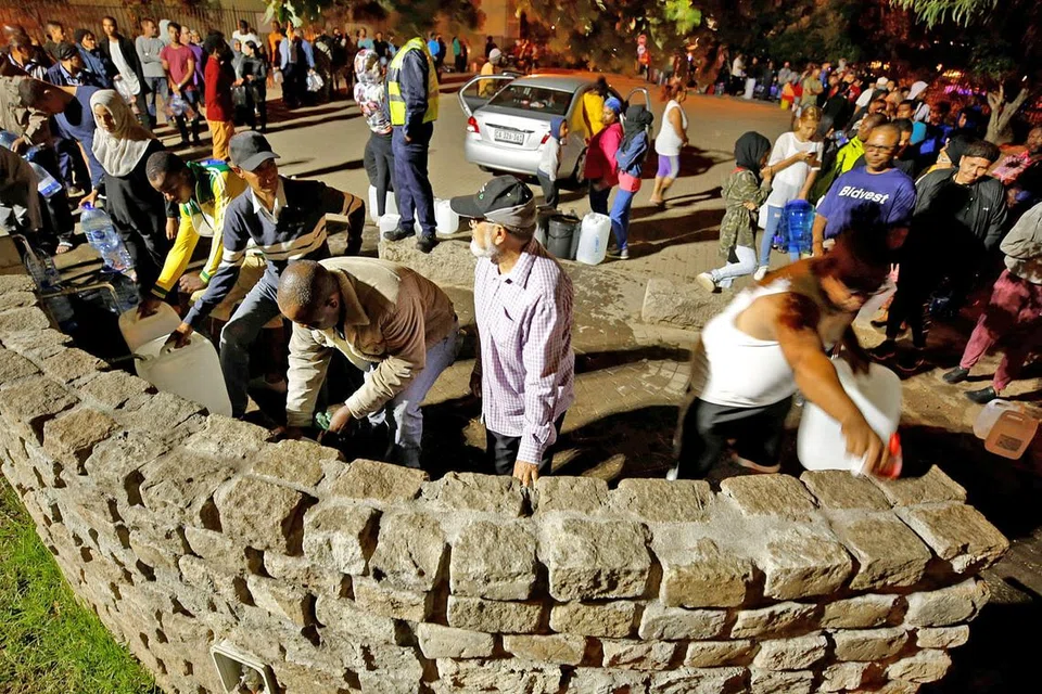BERATUR PANJANG: Penduduk menunggu giliran mengambil air dari mata air di bandar Newlands sedang kebimbangan meningkat berkaitan kekurangan air di Cape Town. - Foto REUTERS