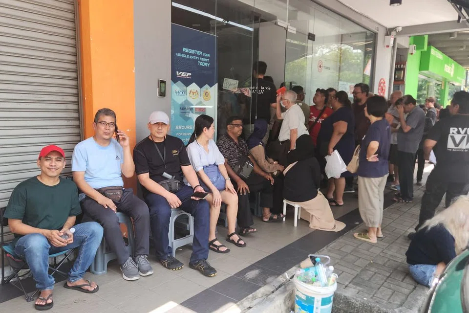 Warga Singapura, Encik Rasidi Awang (dua dari kiri) dan Encik Muhd Alhakim Salim (tiga dari kiri) sedang menunggu giliran mereka untuk memasuki pejabat TCSens di Danga Bay bagi mendapatkan maklumat mengenai VEP. 