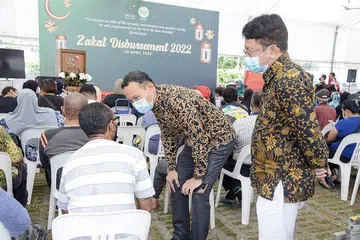 PERGIAT KUMPUL DANA: Darul Arqam antara lain merancang anjur Gerai Ramadan di premis mereka semasa bulan puasa akan datang bagi pertingkat kunjungan tetap ke persatuan itu dengan harapan menarik lebih ramai bayar zakat dan menderma kepada persatuan tersebut. Gambar ini diambil di acara pemberian zakat di Darul Arqam Ramadan lalu dengan Mayor CDC South East, Encik Fahmi Aliman (tengah) dilihat beramah dengan salah seorang benefisiari. - Foto DARUL ARQAM