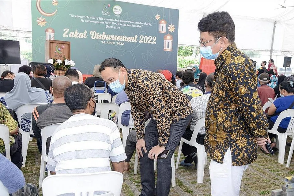 PERGIAT KUMPUL DANA: Darul Arqam antara lain merancang anjur Gerai Ramadan di premis mereka semasa bulan puasa akan datang bagi pertingkat kunjungan tetap ke persatuan itu dengan harapan menarik lebih ramai bayar zakat dan menderma kepada persatuan tersebut. Gambar ini diambil di acara pemberian zakat di Darul Arqam Ramadan lalu dengan Mayor CDC South East, Encik Fahmi Aliman (tengah) dilihat beramah dengan salah seorang benefisiari. - Foto DARUL ARQAM