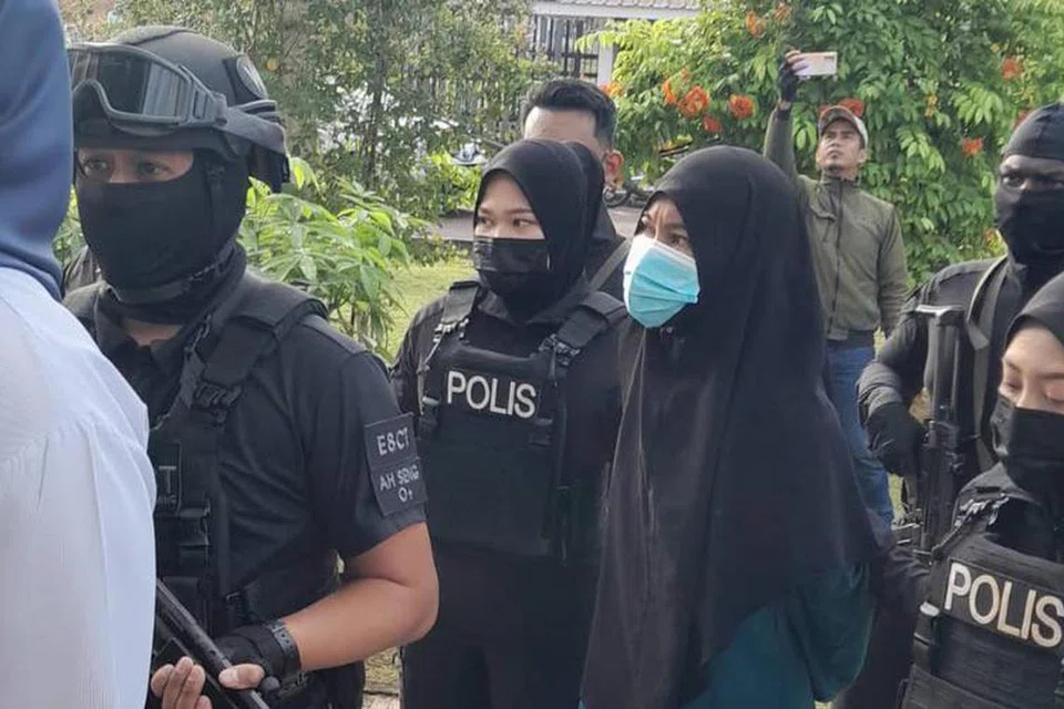Suhaina Sarwan (memakai pelitup), yang menghadapi tuduhan memiliki bahan berkaitan kumpulan pengganasan ISIS, dibawa ke Mahkamah Sesyen Kota Tinggi, Johor, pada 27 Jun, dengan kawalan ketat polis. 