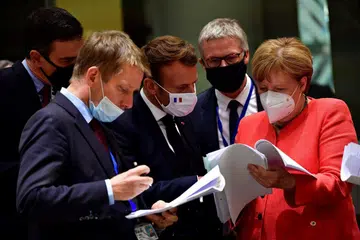 BINCANG TENTANG PAKEJ BANTUAN: Canselor Jerman Angela Merkel (kanan) berbual dengan Presiden Perancis Emmanuel Macron (tengah) semasa perbincangan pada hari keempat sidang kemuncak pemimpin Majlis Eropah Khas di Brussels, Belgium. - Foto EPA-EF