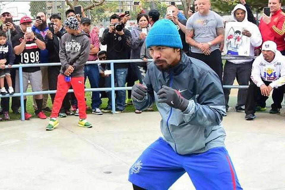 BUAT PERSIAPAN: Orang ramai berkumpul menyaksikan petinju Filipina, Manny Pacquiao, berlatih di sebuah taman selepas berlari-lari anak di Los Angeles. - Foto AFP