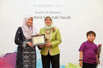 TERIMA PENGHARGAAN: Presiden Halimah (kanan) memberi cenderahati kepada wakil Berita Harian, Cik Norhaiza Hashim sebagai mengiktiraf sumbangan akhbar ini mengumpul $30,000 kepada Cabaran Presiden. - Foto BH oleh GAVIN FOO