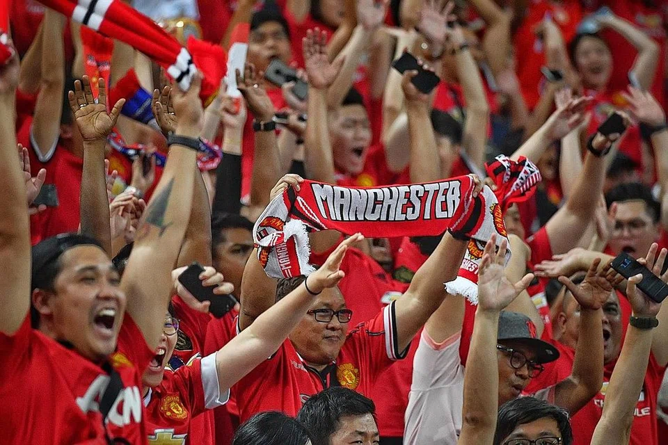 SETIA MENYOKONG: Peminat Manchester United bersorak semasa perlawanan kelab England itu menentang Inter Milan di Stadium Negara, Singapura pada 2019. - Foto fail BH