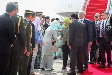 PERKUKUH HUBUNGAN: Puan Halimah (tengah) bersama suami Encik Mohamed Abdullah Alhabshee (tiga dari kanan) disambut pegawai dan tokoh kanan Brunei di Lapangan Terbang Antarabangsa Brunei semalam. - Foto BH oleh GAVIN FOO