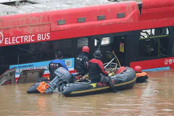MATI TERPERANGKAP: Pekerja penyelamat Korea Selatan mencari orang hilang berhampiran bas di jalan menuju ke terowong bawah tanah di mana kira-kira 15 kereta terperangkap dalam air banjir selepas hujan lebat di Cheongju pada 16 Julai 2023.