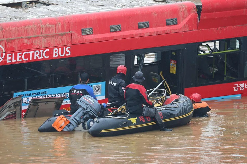 MATI TERPERANGKAP: Pekerja penyelamat Korea Selatan mencari orang hilang berhampiran bas di jalan menuju ke terowong bawah tanah di mana kira-kira 15 kereta terperangkap dalam air banjir selepas hujan lebat di Cheongju pada 16 Julai 2023.