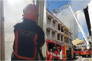 Pegawai SCDF cuba memadamkan api di rumah kedai di 31 Teo Hong Road di Outram Park pada 15 Jun 2021. - Foto-foto FACEBOOK/SINGAPORE CIVIL DEFENCE FORCE
