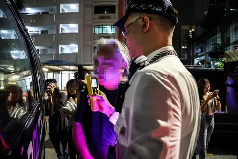 UJIAN PERNAFASAN: Seorang pegawai Polis Trafik melakukan satu ujian pernafasan untuk mengukur berapa banyak alkohol berada dalam udara yang dihembus pemandu itu.