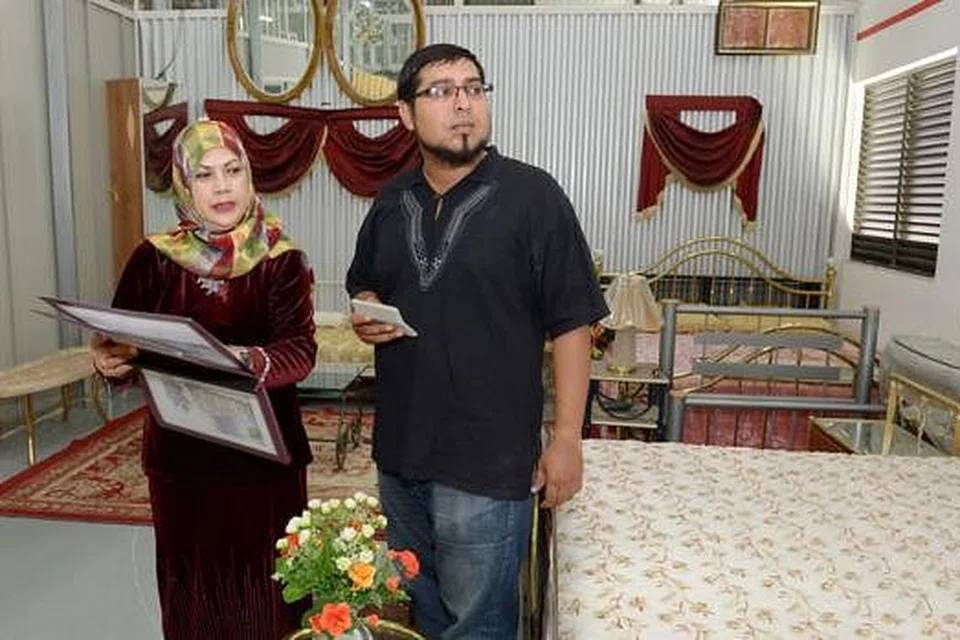 BANTU SME: Pemilik firma perabot Brass & Metal Furniture Pte Ltd, Cik Noraini Abdul Rahman, sedang menunjukkan salah seorang pengasas Kelab Ethis, Encik Umar Munshi, beberapa katil yang diperolehi hasil pembiayaan anggota pelabur Kelab Ethis. - Foto TUKIMAN WARJI