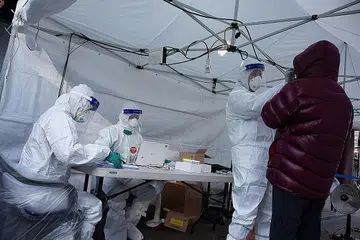 UJI PESAKIT: Seorang kakitangan perubatan melakukan ujian Covid-19 ke atas seorang warga di klinik mudah alih di Seoul, Korea Selatan, semalam. - Foto EPA-EFE