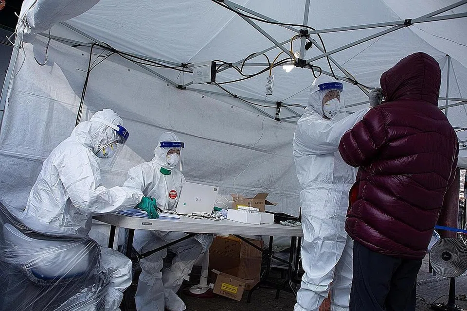 UJI PESAKIT: Seorang kakitangan perubatan melakukan ujian Covid-19 ke atas seorang warga di klinik mudah alih di Seoul, Korea Selatan, semalam. - Foto EPA-EFE