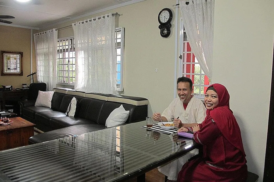 RUMAHKU SYURGAKU: Encik Nidzam, yang sedang menjamu selera bersama isterinya, Cik Mastura, tidak berhasrat menjual flat lima bilik mereka di Redhill Lane meskipun harga telah naik berlipat ganda. - Foto BM oleh SAINI SALLEH