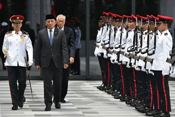 Leftenan-Jeneral (LG) (Bersara) Sjafrie Sjamsoeddin (dua dari kini), memerhatikan Kawalan Kehormatan apabila tiba di  Singapura pada 20 Januari sambil diapit Menteri Pertahanan, Dr Ng Eng Hen.