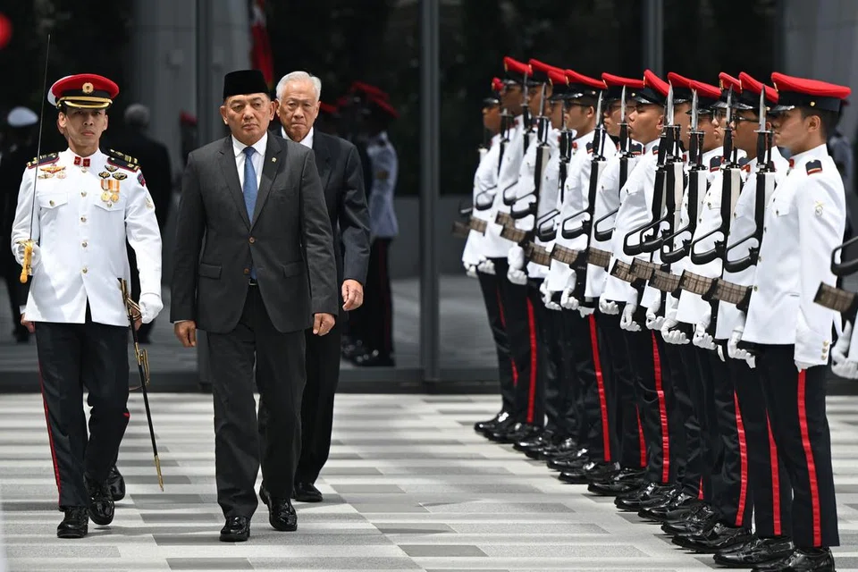 Leftenan-Jeneral (LG) (Bersara) Sjafrie Sjamsoeddin (dua dari kini), memerhatikan Kawalan Kehormatan apabila tiba di  Singapura pada 20 Januari sambil diapit Menteri Pertahanan, Dr Ng Eng Hen.