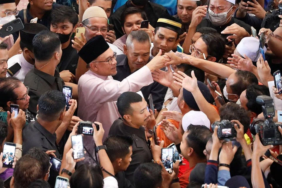 RAKYAT BERSESAKAN: Datuk Seri Anwar Ibrahim bertemu penyokongnya selepas menunaikan sembahyang Jumaat di Masjid Putra, Putrajaya, pada hari pertama beliau memulakan tugas rasmi sebagai Perdana Menteri Malaysia ke-10, kelmarin. - Foto REUTERS 