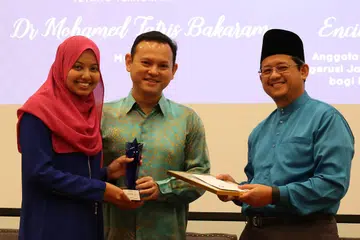 IKRAR WASATIYAH: Ikrar Wasatiyah yang bermaksud kesederhanaan hasil karya Cik Afifah Sheik Abdul Salam (kiri) berjaya menambat hati pengadil sekali gus menjadikannya juara bagi Peraduan Esei Cabaran Mufti tahun ini. Hadiah wang tunai $2,000 dan trofi disampaikan kepada Cik Afifah oleh Encik Zaqy Mohamad (tengah) dan Mufti Dr Mohamed Fatris Bakaram (kanan). - Foto PUTRI MARDHIYAH YAZID