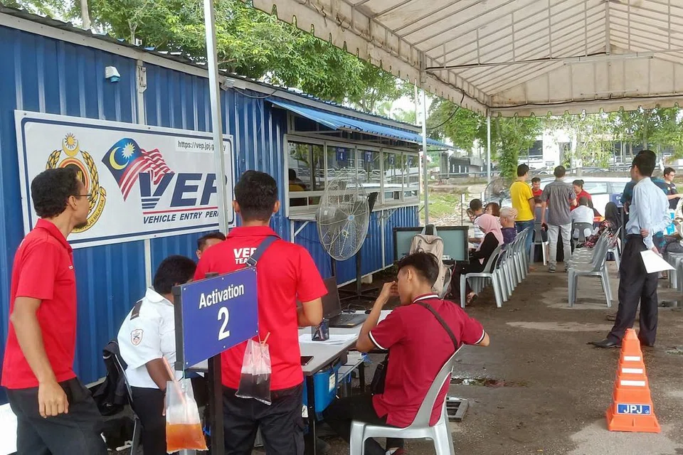 AMBIL DAN PASANG TAG VEP: Pemilik kereta Singapura dikenakan bayaran RM10 ($3.30) untuk memproses, memasang, mengaktifkan dan menguji tag VEP di tempat meletak kereta terbuka dekat Plaza Angsana. - Foto BH oleh SAINI SALLEH