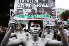 Lelaki yang dikenali sebagai ‘Silver Men’ memegang plakad semasa tunjuk perasaan solidariti bersama rakyat Palestin di Gaza sempena ulang tahun kedua perang yang tercetus selepas serangan Hamas terhadap Israel pada 7 Oktober 2023, di hadapan Kedutaan Amerika Syarikat di Jakarta, Indonesia, pada 7 Oktober 2025.
