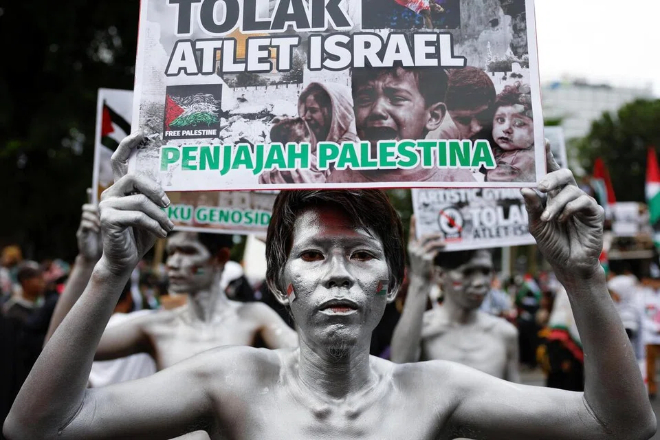Lelaki yang dikenali sebagai ‘Silver Men’ memegang plakad semasa tunjuk perasaan solidariti bersama rakyat Palestin di Gaza sempena ulang tahun kedua perang yang tercetus selepas serangan Hamas terhadap Israel pada 7 Oktober 2023, di hadapan Kedutaan Amerika Syarikat di Jakarta, Indonesia, pada 7 Oktober 2025.
