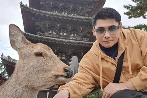 Encik Muhamad Fariqqin Anuar mengambil swafoto bersama rusa di dalam taman Nara pada Januari 2023.