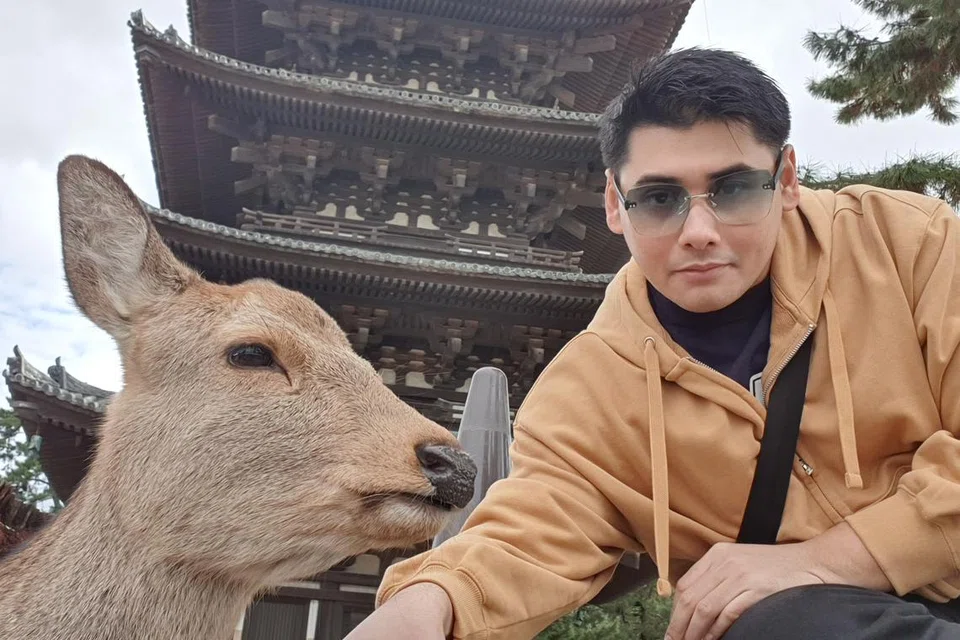 Encik Muhamad Fariqqin Anuar mengambil swafoto bersama rusa di dalam taman Nara pada Januari 2023.