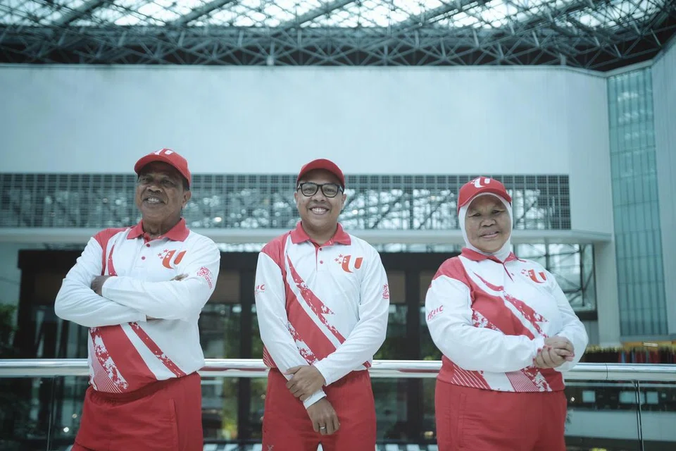 BERSEMANGAT: Selepas sekitar 15 tahun masing-masing menyertai Perbarisan Hari Kebangsaan dalam kontingen NTUC, tahun ini kali pertama Encik Johari Arwee (paling kiri) dan isterinya Cik Siti Sa’diah Kemat (paling kanan), berbaris dalam kontinjen itu bersama dengan anak sulung mereka Encik Mohammad Sha’ari Johari (tengah).