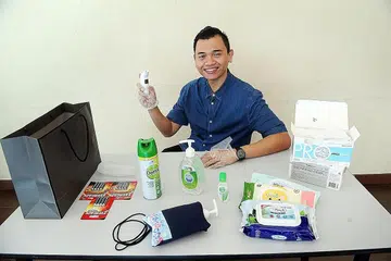 PENGANTIN BERSIAP SEDIA: Encik Farid menyiapkan barangan seperti termometer dan sanitiser untuk digunakan bagi majlis perkahwinannya bersama Cik 'Aisyah nanti. - Foto BH oleh ALPHONSUS CHERN